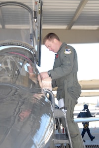 Maj. Rusty Wallace, 340th Flying Training Group, goes through a pre-flight checklist at the cockpit of a T-38 on the Randolph flight line.  (Photo by Steve White)