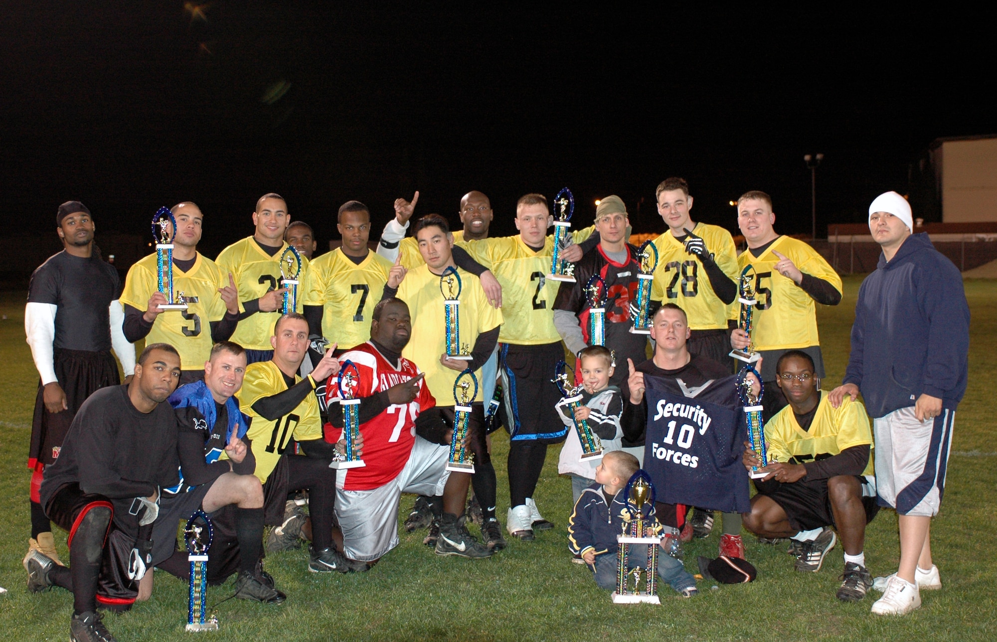 Members of the 60th Security Forces Squadron flag football team pose with their championship trophies after narrowly defeating the 60th Operations Support Squadron by a score of 7-6. (U.S. Air Force photo by Staff Sgt. Candy Knight)