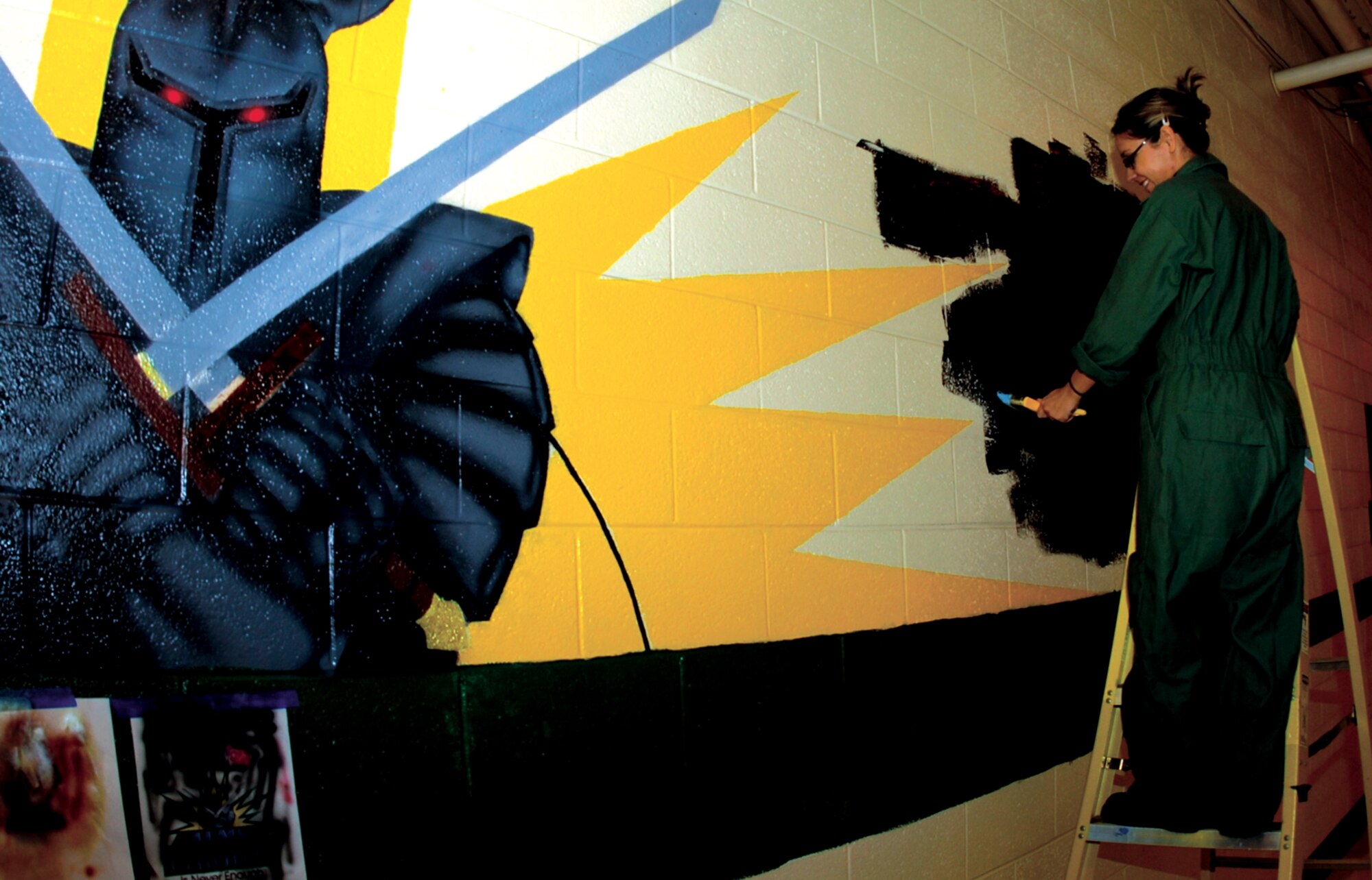 SEYMOUR JOHNSON AIR FORCE BASE, N.C. - Senior Airman Angie Madole paints a mural at the 4th Equipment Maintenance Squadron headquarters building on hangar row. 