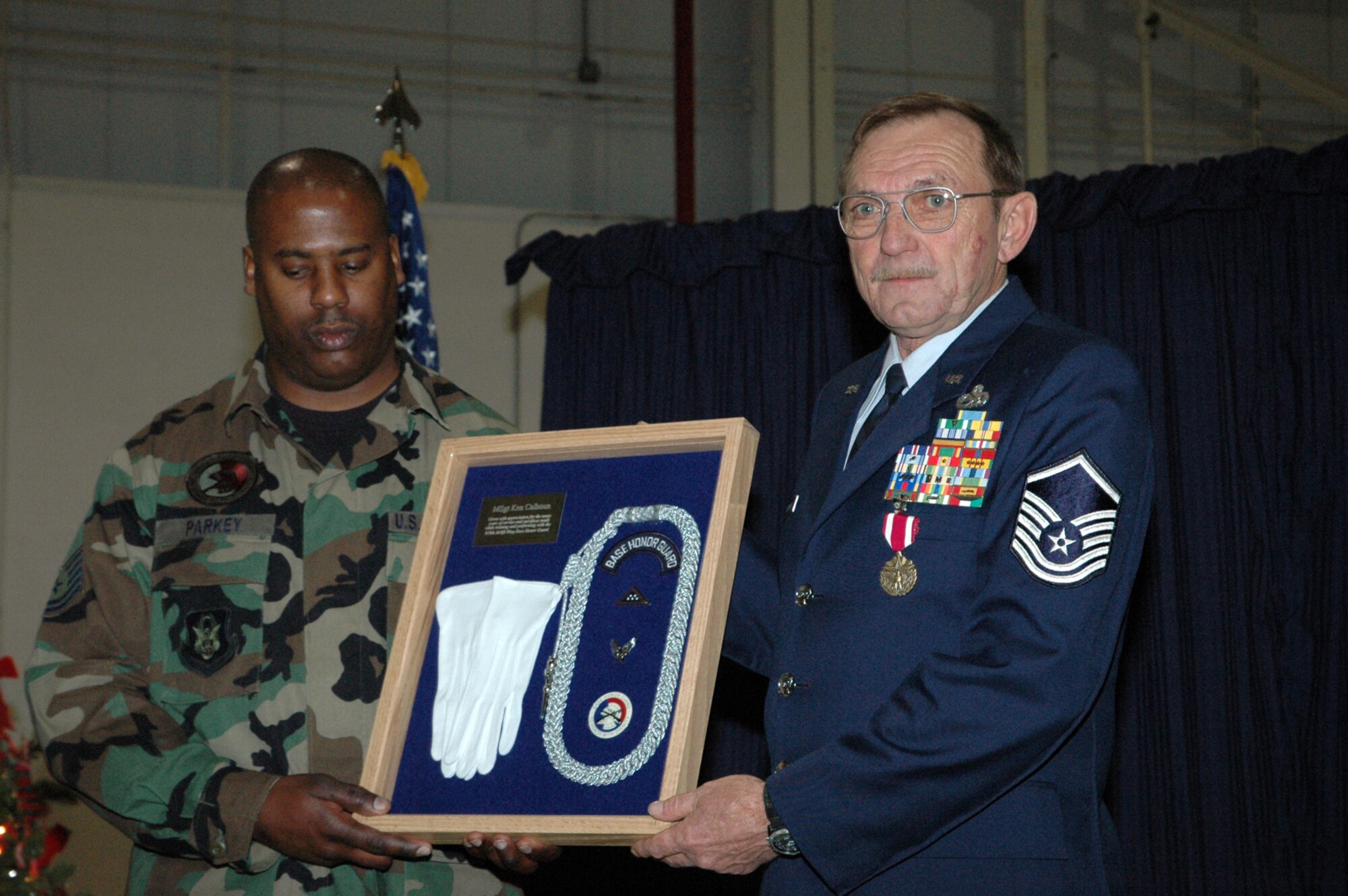 YOUNGSTOWN AIR RESERVE STATION, Ohio -- Air Force Reserve Master Sgt. Kenneth E. Calhoun, crew chief for C-130 aircraft 92-3021, receives special recognition from Tech. Sgt. Leslie Parkey, representing the 910th Airlift Wing Honor Guard, during Sergeant Calhoun's retirement ceremony here Dec. 2, 2006.  Sergeant Calhoun was one of the founding members of the 910th Honor Guard in the 1980's.  U.S. Air Force photo/Master Sgt. Bryan Ripple.