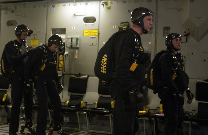 Chip Bowlin, Al Vernon, Andy Burch and Andy Serrano (left to right) wait for the cargo door ramp of a Charleston Air Force Base C-17 Globemaster III to open prior to their jump over the Miami Dolphins football game Oct. 10. Mr. Serrano, Mr. Burch, Mr. Vernon and Mr. Bowlin are retired Soldiers who volunteer as members of the U.S. Special Operations Command Parachute Demonstration Team from MacDill Air Force Base, Fla.  (U.S. Air Force photo/Tech. Sgt. Paul Kilgallon)