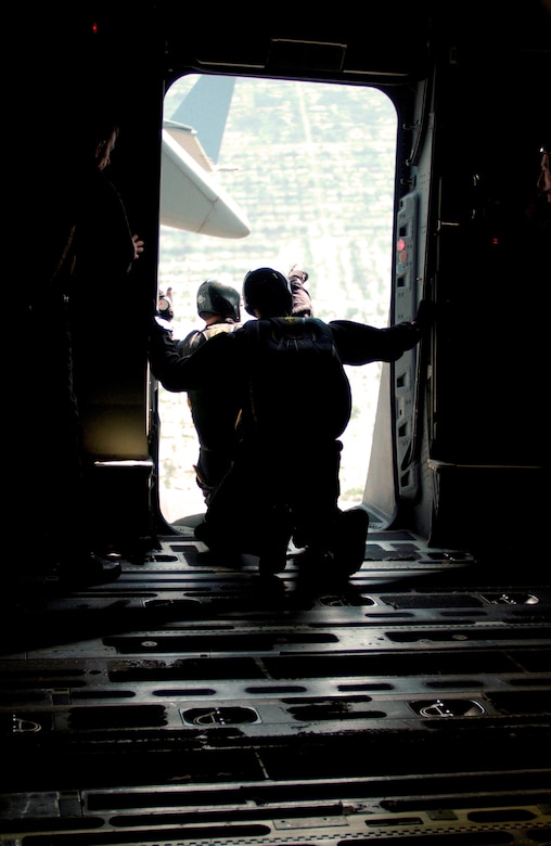 Andy Serrano (front) assisted by Chip Bowlin (rear) locate drop-markers released from the side of a Charleston Air Force Base C-17 Globemaster III prior to their jump over the Miami Dolphins football game Oct. 10. Mr. Serrano and Mr. Bowlin are retired Soldiers who volunteer as members of the U.S. Special Operations Command Parachute Demonstration Team from MacDill Air Force Base, Fla.  (U.S. Air Force photo/Tech. Sgt. Paul Kilgallon)