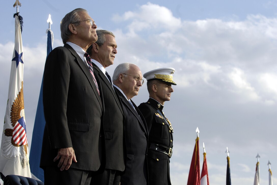 Defense Secretary Donald H. Rumsfeld, President George W. Bush, Vice President Dick Cheney, and U.S. Marine Gen. Peter Pace, chairman of the Joint Chiefs of Staff, stand at attention as the troops march in review  during Rumsfeld's farewell parade at the Pentagon, Dec. 15, 2006.
