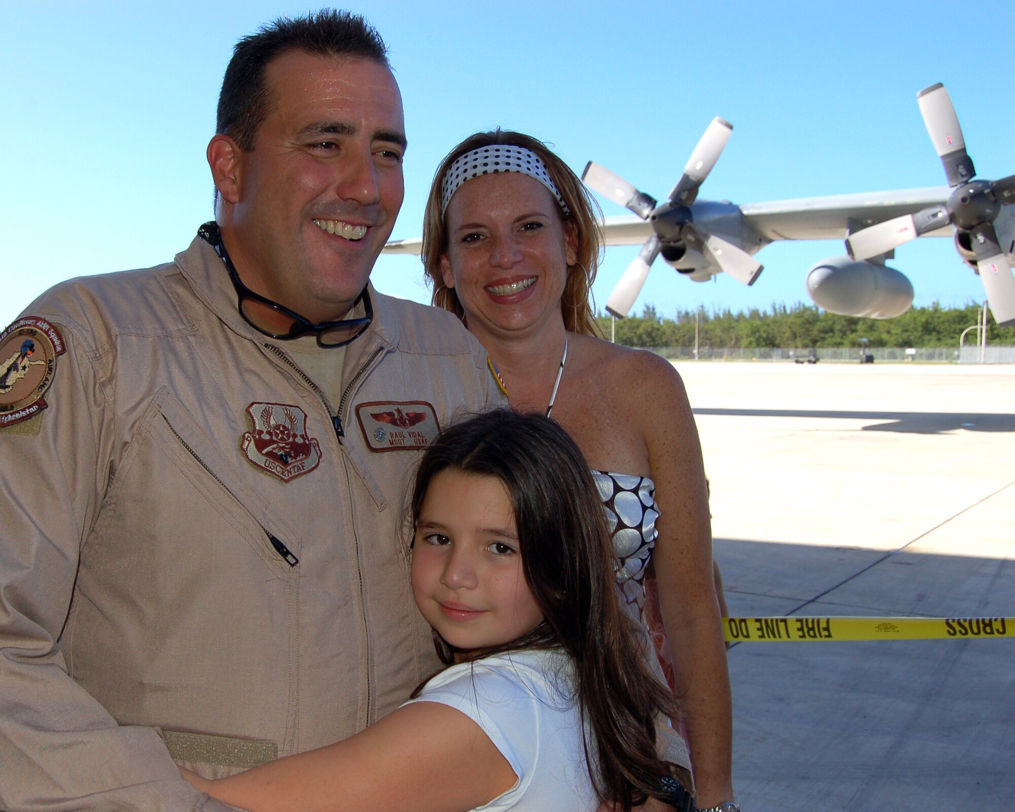 Master Sgt. Jose Vidal gets a hug from his wife, Giselle, and daughter, Marina, after his return home to Muñiz Air National Guard Base, Puerto Rico, Dec. 16. The 198th Airlift Squadron loadmaster deployed to Bagram Air Base, Afghanistan. The unit is part of the 156th Airlift Wing of the Puerto Rico Air National Guard. (U.S. Air Force photo/Louis A. Arana-Barradas) 
