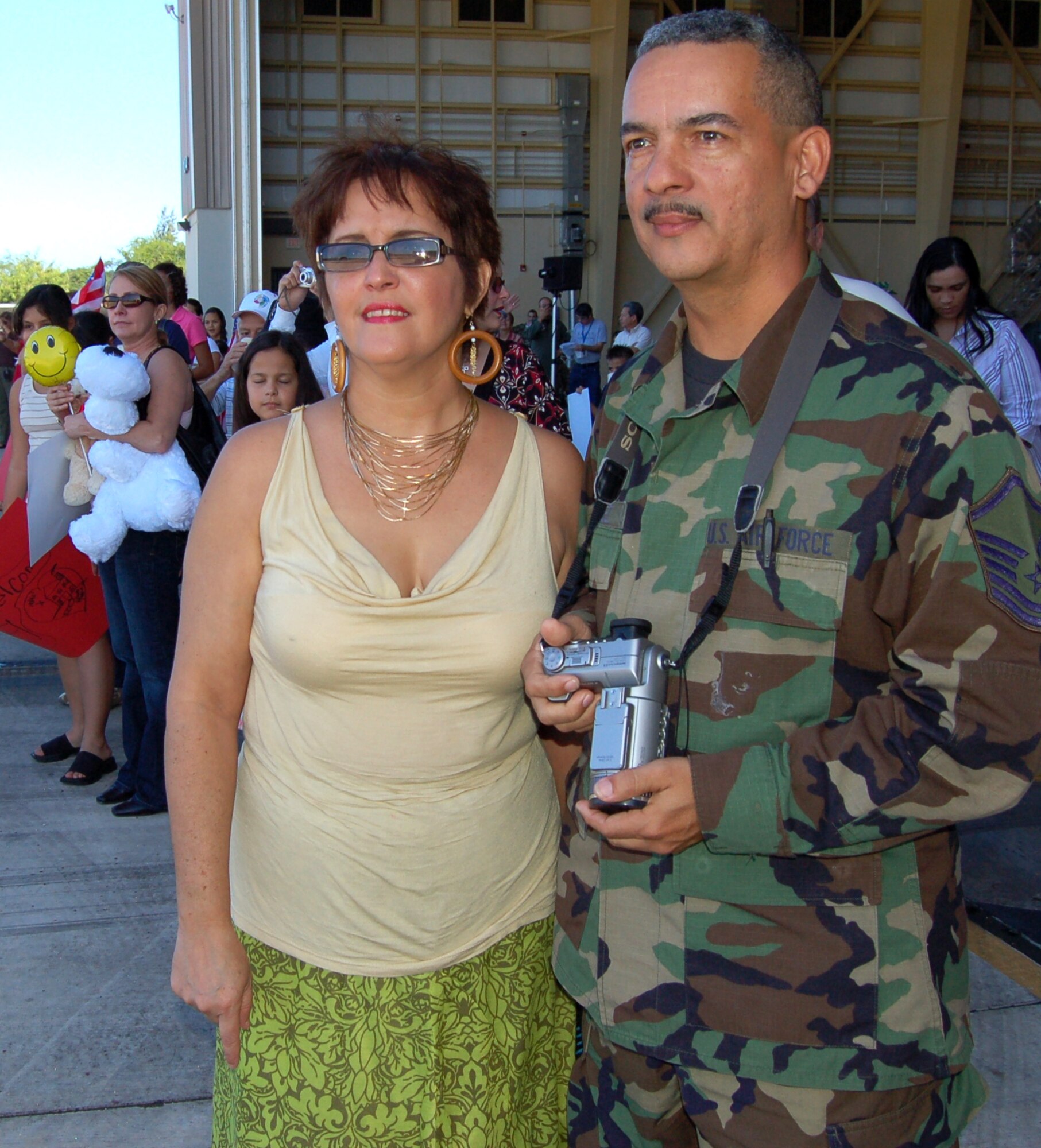 Master Sgt. Diego Vazquez and his wife, Milly, wait for Airmen from the 198th Airlift Squadron to arrive at Muñiz Air National Guard Base, Puerto Rico, Dec. 16. The 156th Airlift Wing NCO in charge of finance also helped in-process the 26 Airmen who returned from a deployment to Bagram Air Base, Afghanistan. The wing is with the Puerto Rico Air National Guard. (U.S. Air Force photo/Louis A. Arana-Barradas)