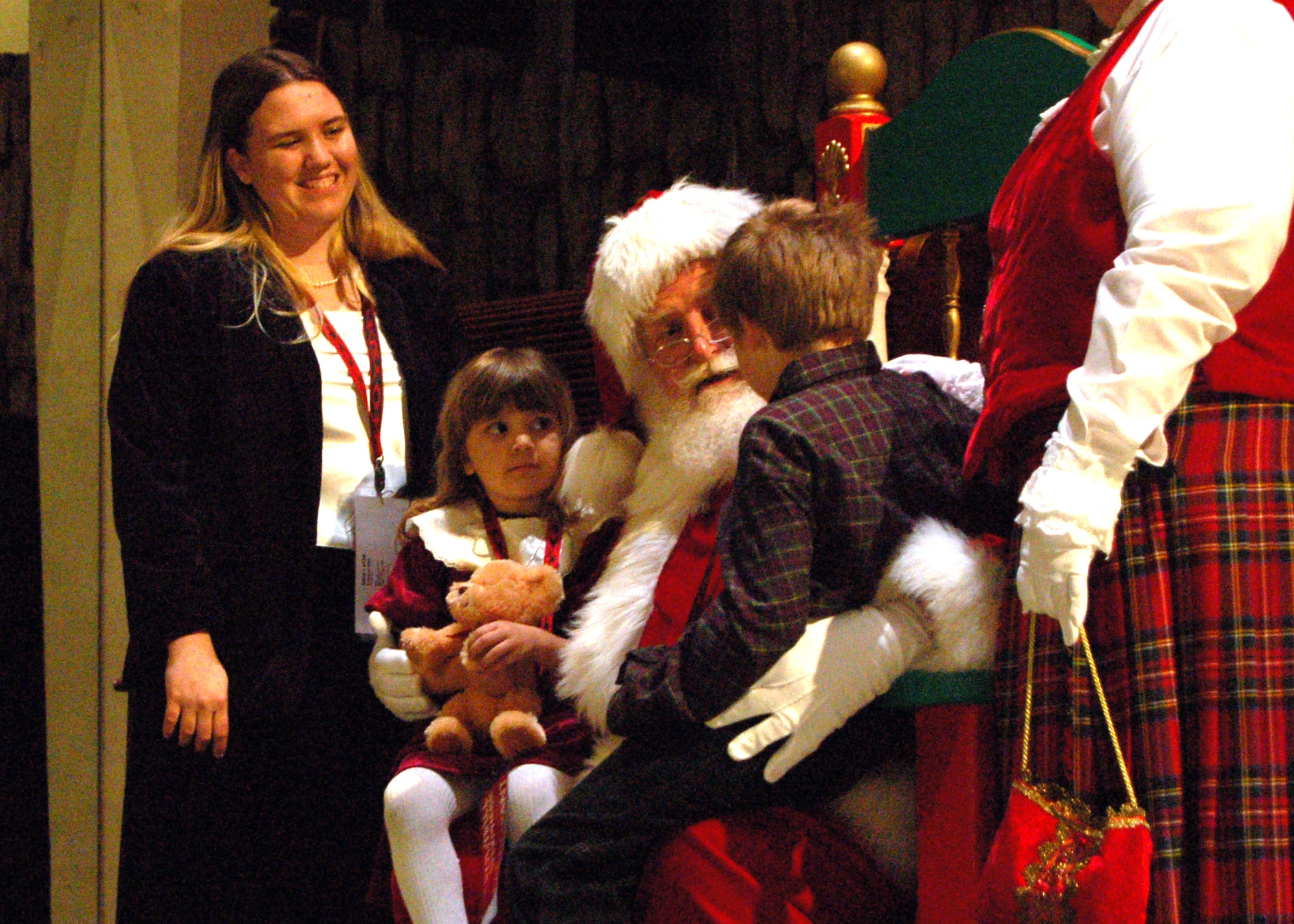Tyler Silva tells Santa what he wants for Christmas while his mom, Shannon and sister, Zoe look on Dec. 15. The meeting took place during the event's kickoff dinner at the Crystal Cathedral. The Snowball Express is a four-day event that includes a trip to Disneyland and tickets to an Anaheim Ducks game. (U.S. Air Force photo/Staff Sgt. Jeremy Larlee) 