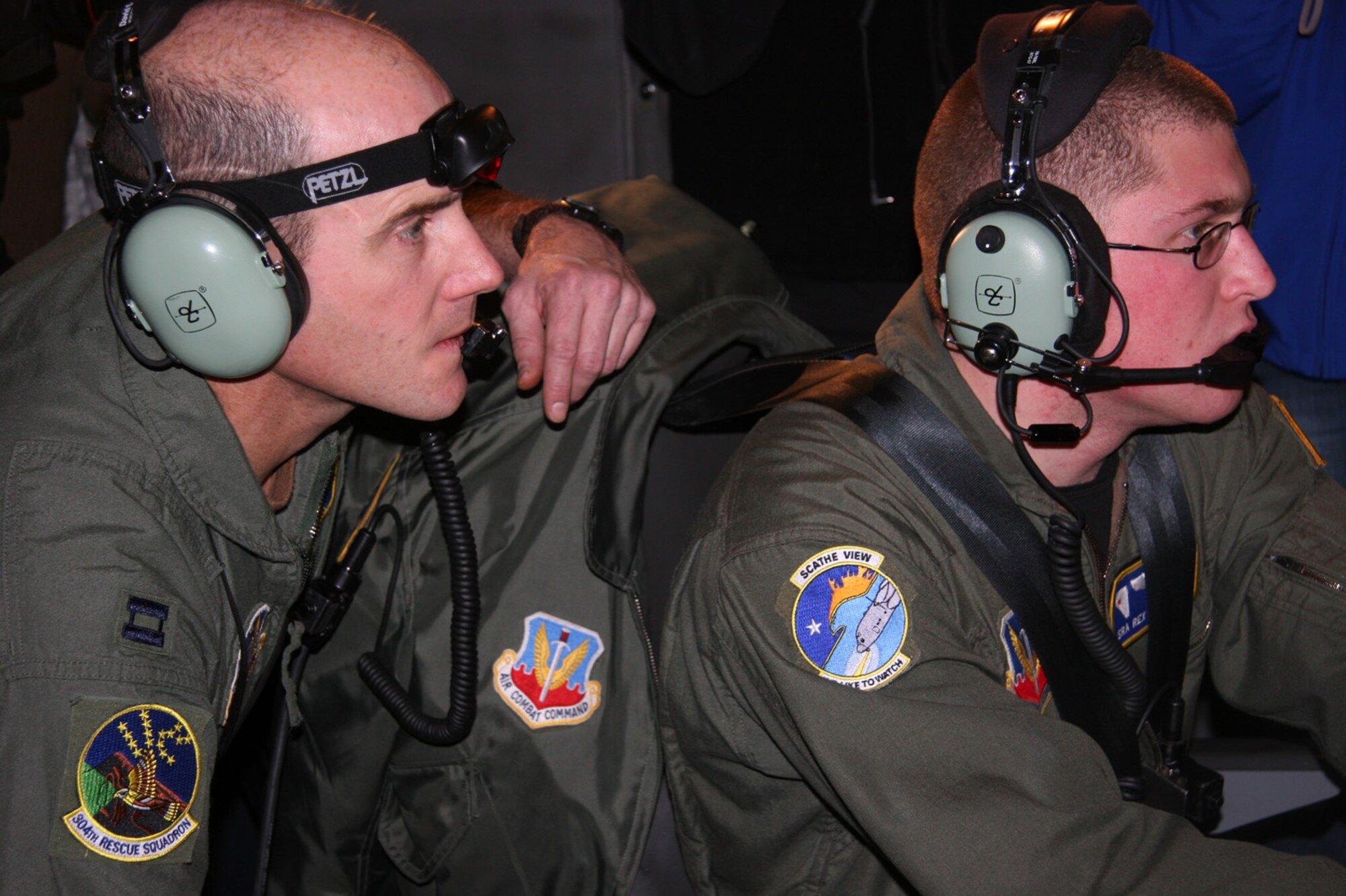 Capt. Ross Willson (left) directs an image analyst to specific coordinates while flying in a C-130H over Mt. Hood, Ore., Dec. 16. Captain Willson, a combat rescue officer from the 304th Rescue Squadron in Oregon, worked with members of the 152nd Airlift Wing from Nevada while aboard the cargo plane equipped with thermal imaging to search for three climbers who left Dec. 7 on what was to be a two-day trip climbing Mt. Hood. The 304th RQS also has two teams of pararescue specialists on the ground battling winds that reached up to 50 mph in an attempt to bring the stranded climbers off the mountain. (U.S. Air Force photo/Maj. James R. Wilson)