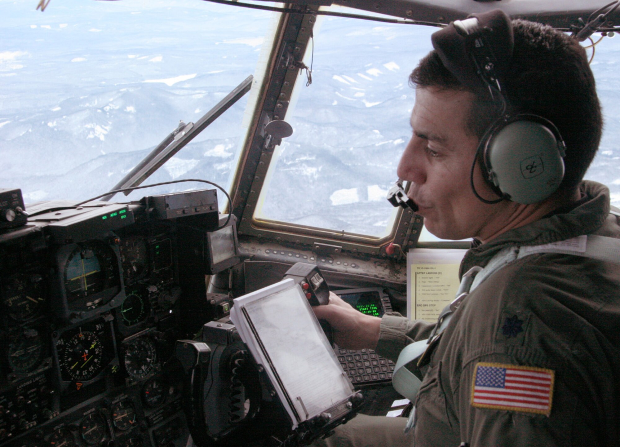 Lt. Col. Caesar Garduno receives coordinates while flying over Mt. Hood, Ore., Dec. 16. Colonel Garduno and his Air National Guard crew were joined by an Air Force Reserve pararescueman searching for three missing climbers. The colonel is a C-130 pilot from the 152nd Airlift Wing in Nevada. (U.S. Air Force photo/Maj. James R. Wilson)