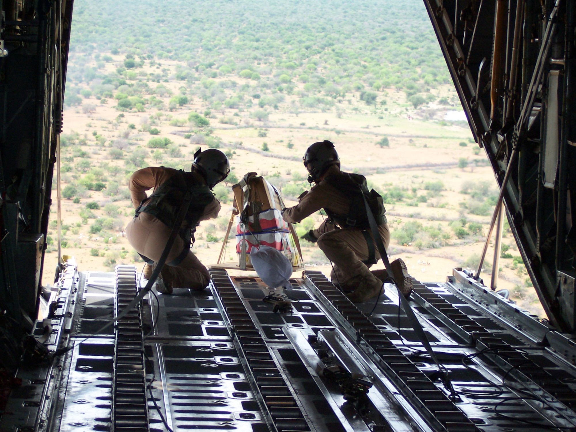 Staff Sgt. Patrick Delselva (left) and Senior Airman Chris Elder roll a miniature pallet of candy off the cargo ramp of a C-130 Hercules Dec. 14 to children in the Dadaab region of northeastern Kenya. In a six-day span the Air Force delivered more than 211,000 pounds of supplies to the region in support of Operation Unity Knight. Both Airmen are deployed to the 746th Expeditionary Airlift Wing in Southwest Asia from Dyess Air Force Base, Texas. (U.S. Air Force photo/Tech. Sgt. Steve Staedler)
