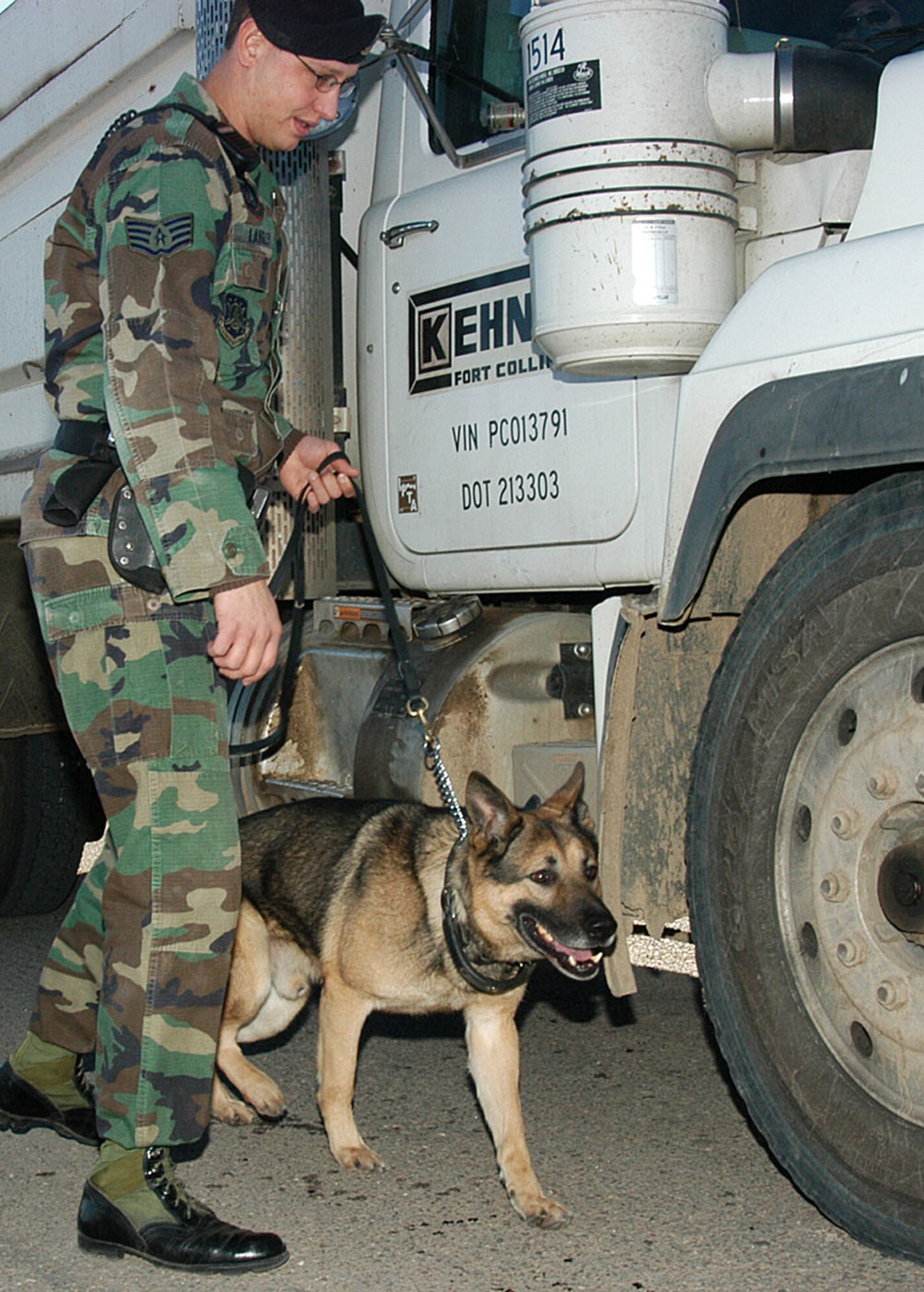 Staff Sgt. Justin Langley, 90th Security Forces Squadron, inspects vehicles with his military working dog, Paco.