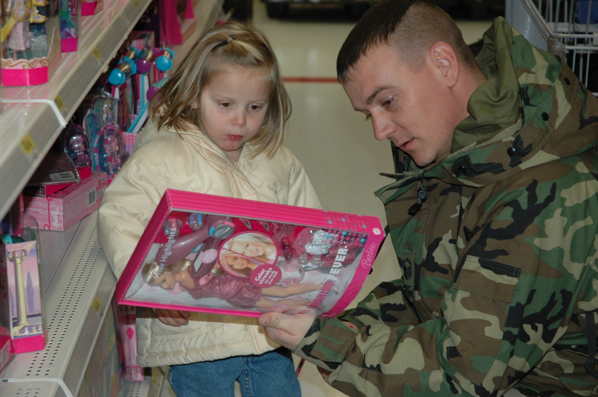 Master Sgt. Ernest Jepperson helps Madison choose a Barbie for a Christmas present.