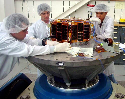 Jamin Greenbaum, The University of Texas at Austin's Nanosatellite-3 FASTRAC program manager (middle), and Eric Rogstad, The University of Texas at Austin's Nanosatellite-4 project manager (right),  assisted by a Jackson and Tull engineer, prepare one of the FASTRAC halves for structural testing at AFRL's Space Vehicles Directorate here. (Air Force photo) 
	
