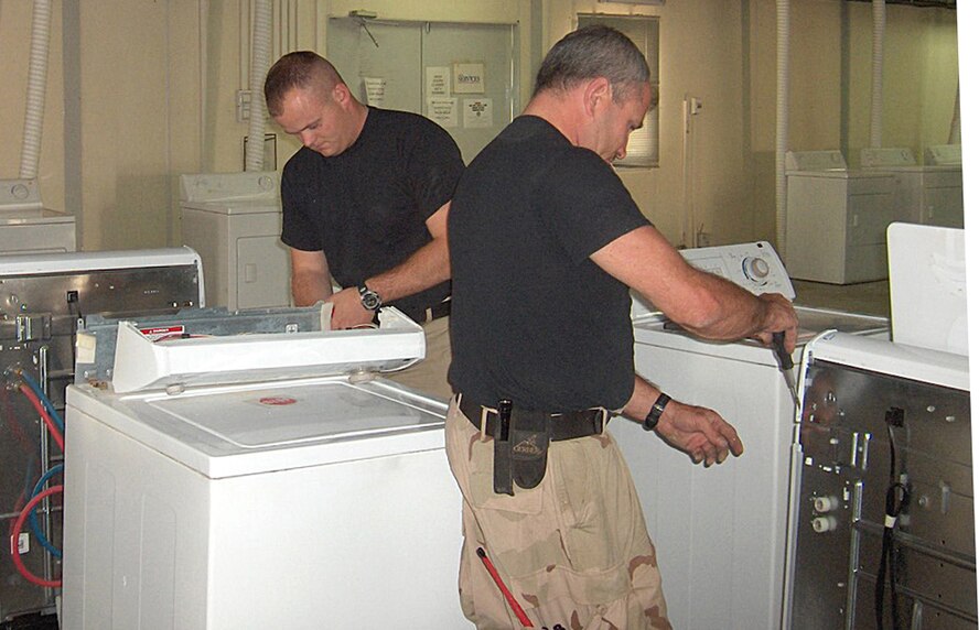 Senior Airman Matt Price and Staff Sgt. Mark Kuhaneck, 506th Expeditionary Civil Engineer, install new washing machines at the Kirkuk Air Base, Iraq self help laundry recently.  Sergeant Kuhaneck is with the 442nd Civil Engineers Squadron. (U.S. Air Force photo/Tech. Sgt. George Proctor)