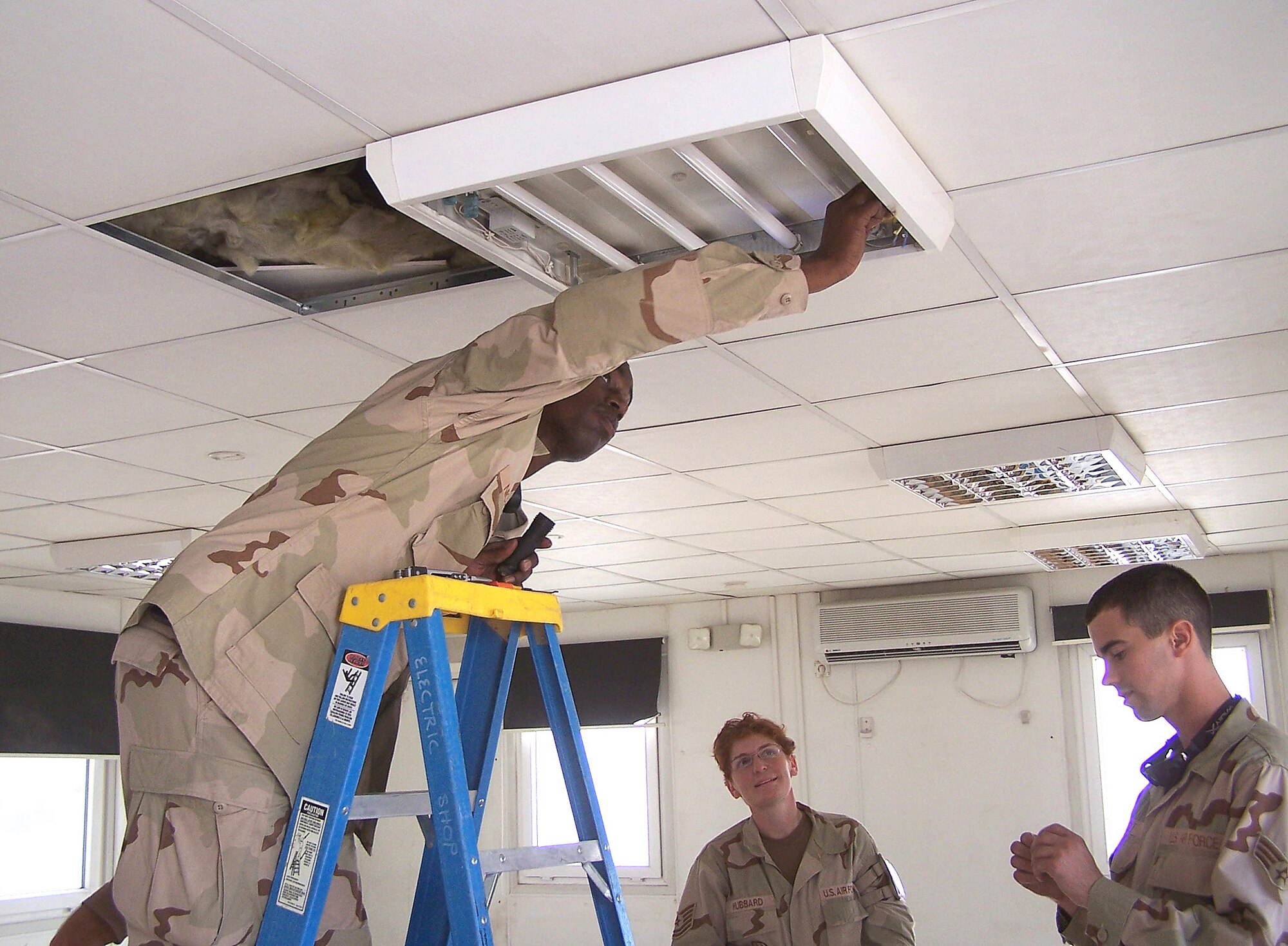 Tech. Sgts. Demetrius Nichols and Erin Hubbard, work with Senior Airman Darren Hardt, deployed to Kirkuk Air Base, Iraq, to re-arrange light fixtures in the base's old iCyber Cafe, which will be the future home for Force Protection, Safety and Public Affairs.
Airman Hardt is one of 30 442nd Civil Engineers Squadron members deployed to the base for expeditionary combat support. (U.S. Air Force photo/Lt. Col Kerry Grimes)