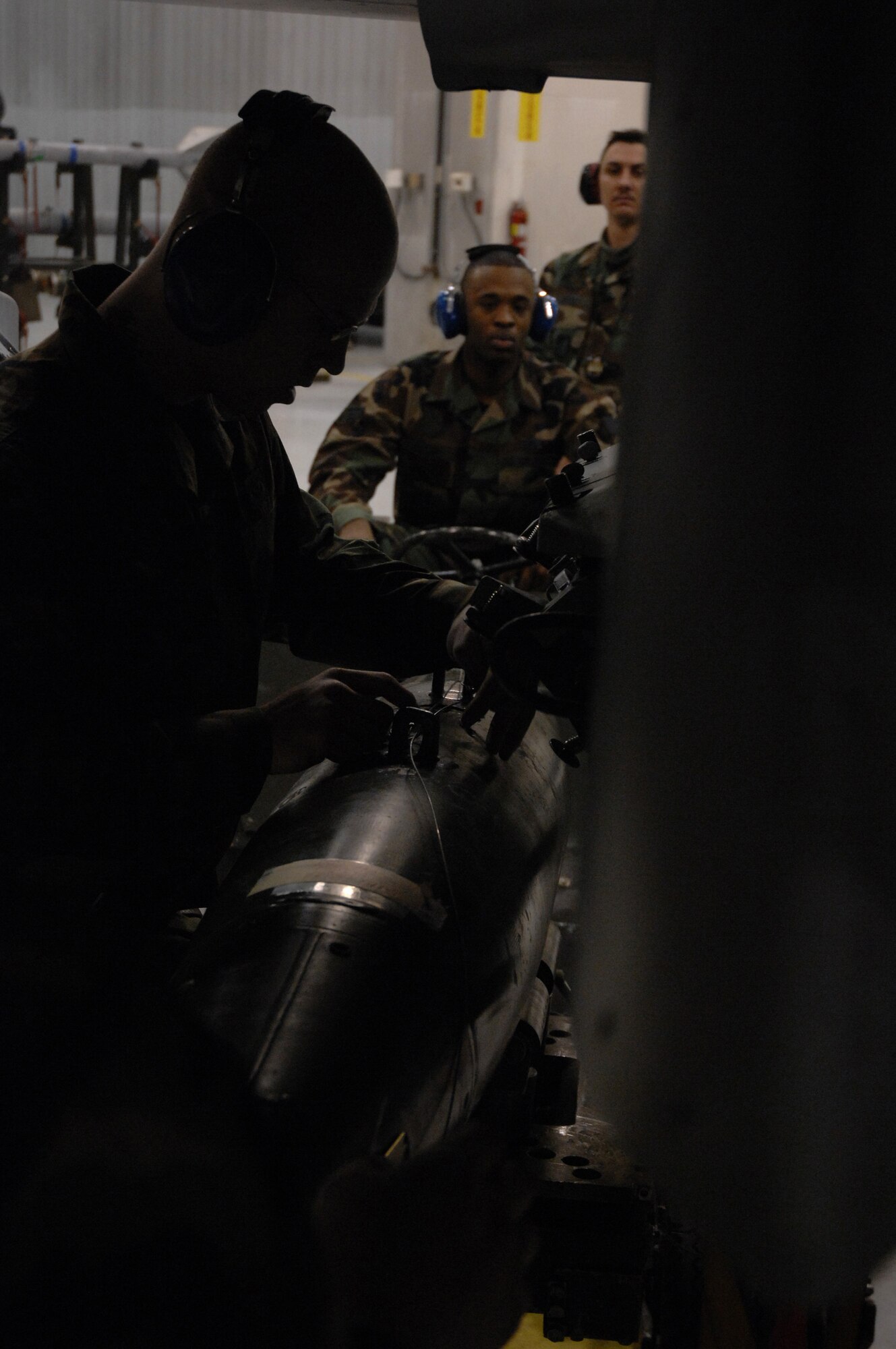 EIELSON AIR FORCE BASE, Alaska -- Staff Sgt Aaron Slay (silhouetted) attaches a MK-82 bomb while Senior Airman Corneilius Cutler (Jammer driver) watches during the Load Crew of the Quarter contest here on 15 December. The Airmen represent the 18th Aircraft Maintenance Unit (AMU) and the quarterly contest pitts the 18th AMU versus the 355th AMU. Both teams loaded 2 MK-82 low drag bombs and one AIM-9 sidewinder missile to their respective aircraft.
(U.S. Air Force Photo by Staff Sgt Joshua Strang)