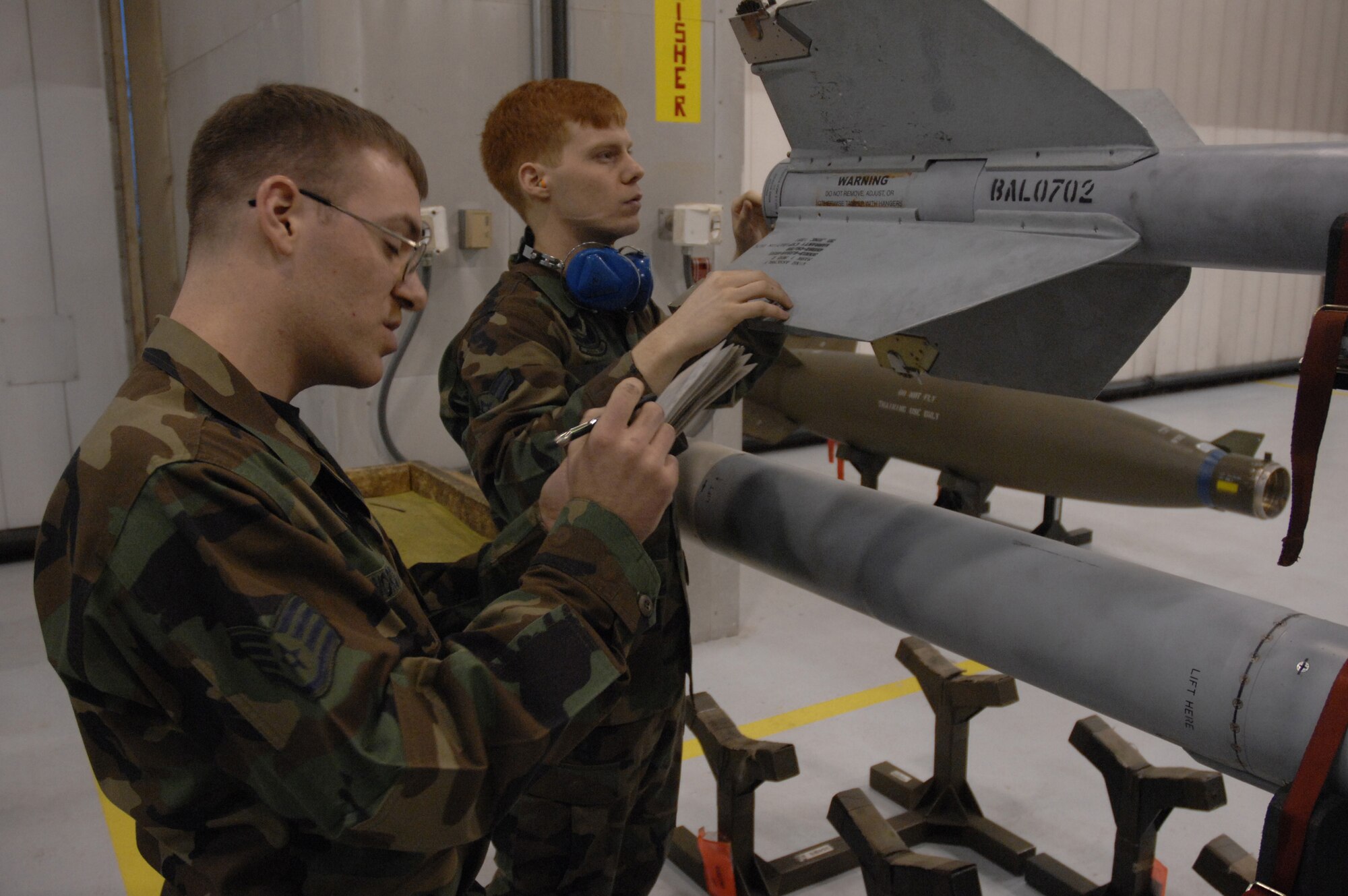 EIELSON AIR FORCE BASE, Alaska -- Staff Sergeant Michael Woroniecki reads over a checklist while Airman 1st Class Joshua Gess inspects a AIM-9 missile during the Load Crew of the Quarter contest here on 15 December. The Airmen represent the 355th Aircraft Maintenance Unit (AMU) and the quarterly contest pitts the 18th AMU versus the 355th AMU. Both teams loaded 2 MK-82 low drag bombs and one AIM-9 sidewinder missile to their respective aircraft.
(U.S. Air Force Photo by Staff Sgt Joshua Strang)