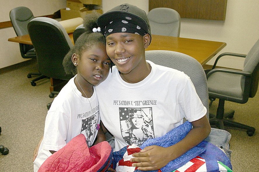 CANNON AIR FORCE BASE, N.M. -- JaKeria and her mother, Keri Williams, hold the quilts made for their family by Operation Homefront Quilters at Cannon. The quilters made seven quilts for the Williams famly in honor of Army Private First Class Satieon "Tee" Greenlee, Keri's brother, who was killed in Iraq in October. Her husband is Senior Airman Andrew Williams, 27th Component Maintenance Squadron, and Operation IRAQI FREEDOM veteran.