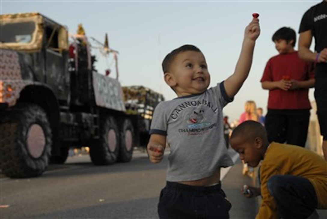 Two-year-old William Figueroa holds up a piece of candy thrown out by Marines on a float in the Camp Kinser Christmas Parade, Okinawa, Japan, Dec. 8.

