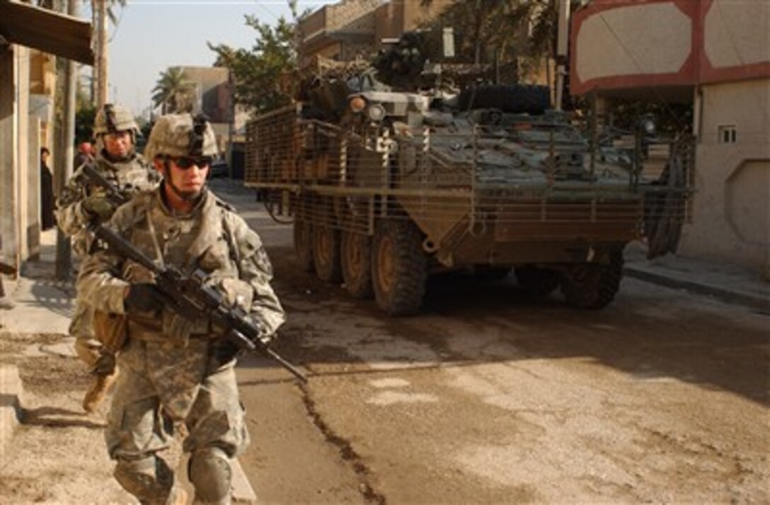 U.S. Army soldiers from 5th Battalion, 20th Infantry Regiment, provide security for Iraqi army soldiers during a patrol in Adhamiya, Iraq, Dec. 11, 2006. The intent of the patrol is to decrease sectarian violence and insurgent activity while increasing the Iraqi security force's capabilities.