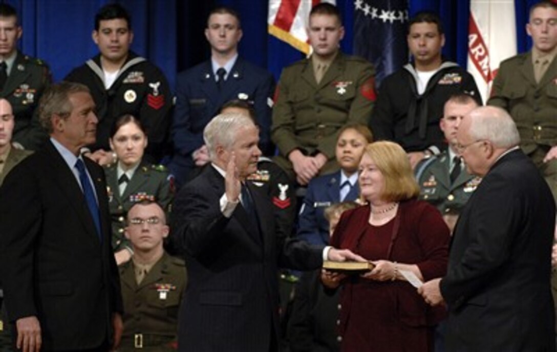 Becky Gates holds the Bible as Robert M. Gates (center) is sworn in as the 22nd secretary of defense by Vice President Dick Cheney (right) at the Pentagon, Dec. 18, 2006.  President George W. Bush (left) looks on. Gates was confirmed Dec. 6, 2006, by the U.S. Senate in a 95-2 vote. 