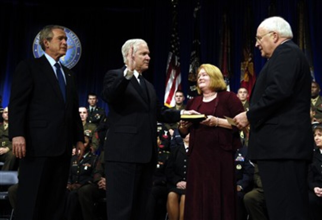 President W. Bush watches as Robert M. Gates is administered the