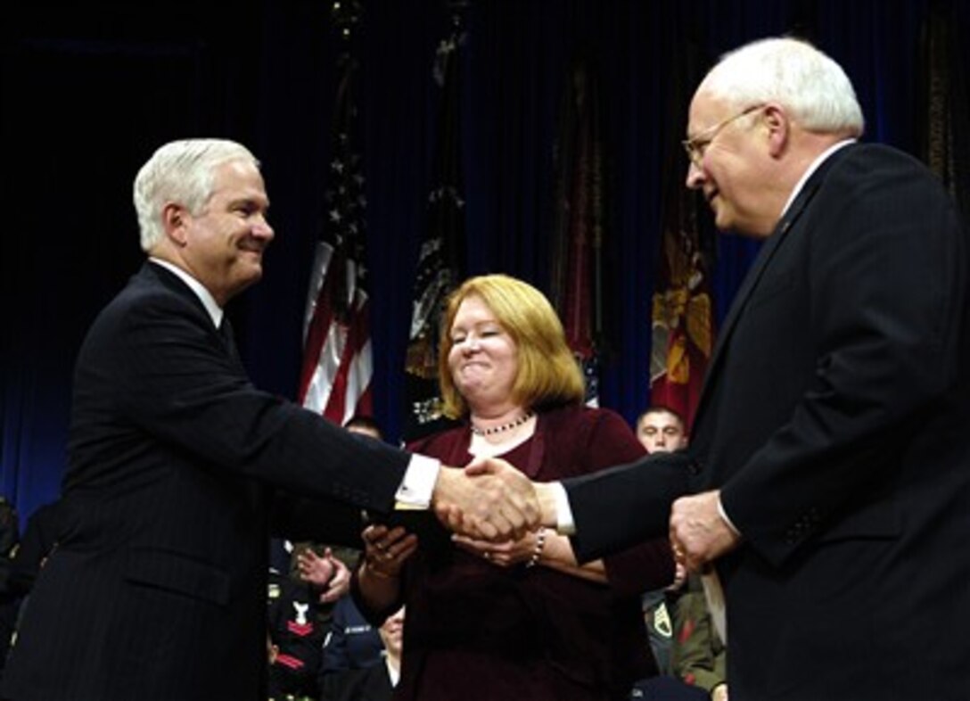 Vice President Dick Cheney (right) shakes hands with Robert Gates (left) the 22nd secretary of defense during an oath of office ceremony in the Pentagon on Dec. 18, 2006.   President George W. Bush presided over the ceremony and Gates’ wife Becky (center) held the Bible during the ceremony.  