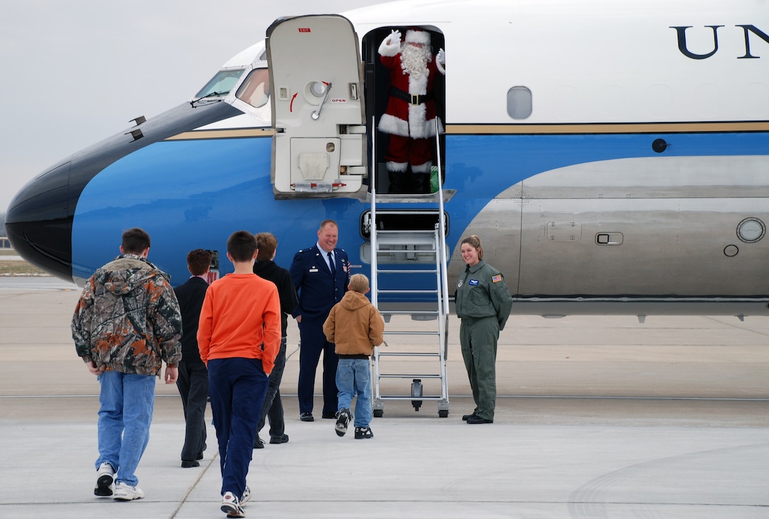 Lt. Col. Kirk Peddicord (932nd Airlift Wing, Maintenance Group commander) and Tech Sgt Elizabeth Wszalek, 73rd Airlift Squadron flight attendant, welcome Santa and children of 932nd Airlift Wing Reservists to board the C-9C aircraft for a little holiday cheer on their recent Unit Training Assembly weekend.  The kids were given a short taxi ride and some candy from Santa and his special elf helper.  The flying mission of the Air Force Reserve Command wing at Scott Air Force Base is distinguished visitor airlift.  Photo/Tech Sgt. Gerald Sonnenberg