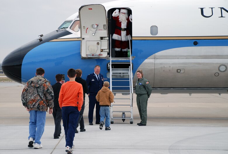 Lt. Col. Kirk Peddicord (932nd Airlift Wing, Maintenance Group commander) and Tech Sgt Elizabeth Wszalek, 73rd Airlift Squadron flight attendant, welcome Santa and children of 932nd Airlift Wing Reservists to board the C-9C aircraft for a little holiday cheer on their recent Unit Training Assembly weekend.  The kids were given a short taxi ride and some candy from Santa and his special elf helper.  The flying mission of the Air Force Reserve Command wing at Scott Air Force Base is distinguished visitor airlift.  Photo/Tech Sgt. Gerald Sonnenberg