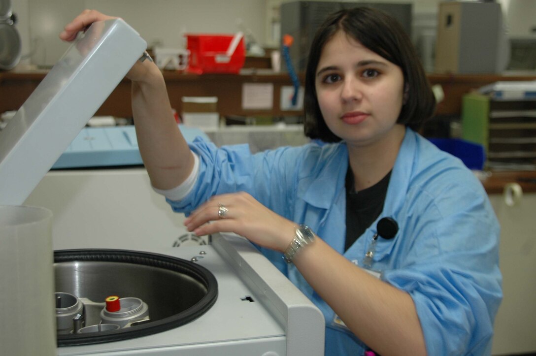 Airman 1st Class Danielle Woodcock, 28th Medical Support Squadron medical laboratory technician, loads a vial of blood into the centrifuge. A centrifuge is a device that separates materials of different density. (Photo by Airman Nathan Riley)