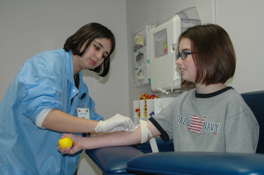 Airman 1st Class Danielle Woodcock, 28th Medical Support Squadron medical laboratory technician, prepares to draw some blood from Lindsey Haugh, age 10. Lindsey Haugh is the daughter of Master Sgt. Peter Haugh, 28th Logistics Readiness Squadron, and Donna Haugh. (Photo by Airman Nathan Riley)