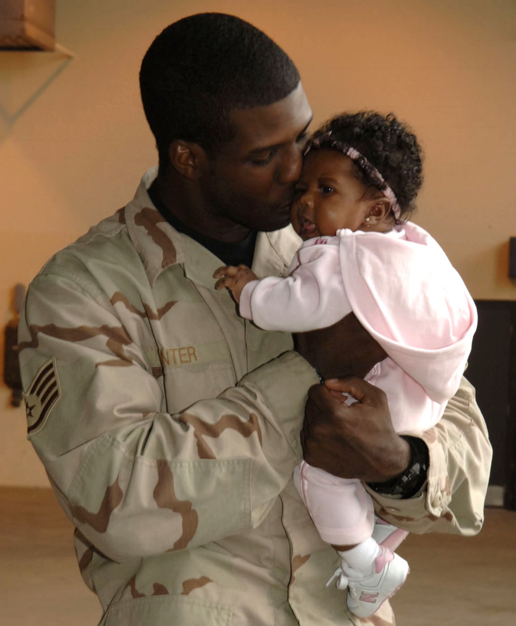 Staff Sgt. Corodney Hunter holds his daughter Jamari at the security forces homecoming ceremony Dec. 14 at Moody Air Force Base, Ga. Deployed members from the 820th Security Forces Group, 23rd SFS and Texas Air National Guard returned home early from their deployment in order to spend the holidays with family and friends. Sergeant Hunter is assigned to the 824th Security Forces Squadron here. (U.S. Air Force photo/Airman 1st Class Elizabeth Rissmiller) 
