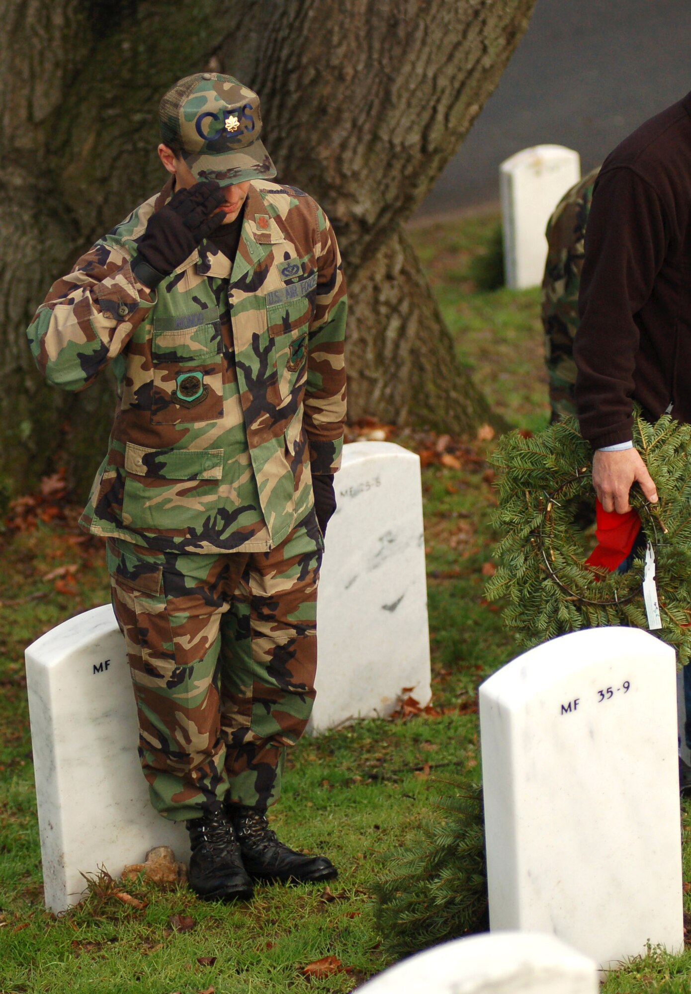 Maj. Frank Mondo salutes the grave he just laid a wreath on Dec. 14 at Arlington National Cemetery, Va. Major Mondo was one of 44 Dover Air Force Base, Del., Airmen who volunteered to lay 5,000 wreaths at the cemetery to honor those servicemembers who passed away. Major Mondo is assigned to the 436th Civil Engineer Squadron. (U.S. Air Force photo/Senior Airman James Bolinger)