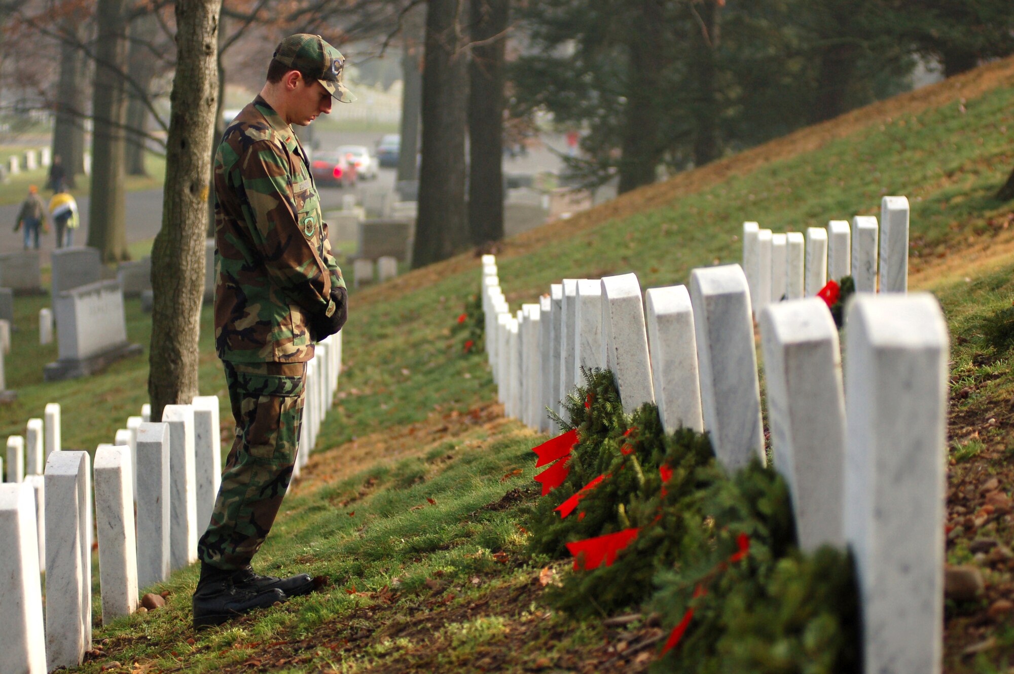 2nd Lt. Kevin Schaekel looks at a wreath he just laid Dec. 14 at Arlington National Cemetery in Virginia. He was one of 44 Dover Air Force Base, Del., Airmen who volunteered to help lay 5,000 wreaths at the cemetery to honor those who have served their country and passed on. Lieutenant Schaekel is assigned to the 436th Civil Engineer Squadron. (U.S. Air Force photo/Senior Airman James Bolinger) 
