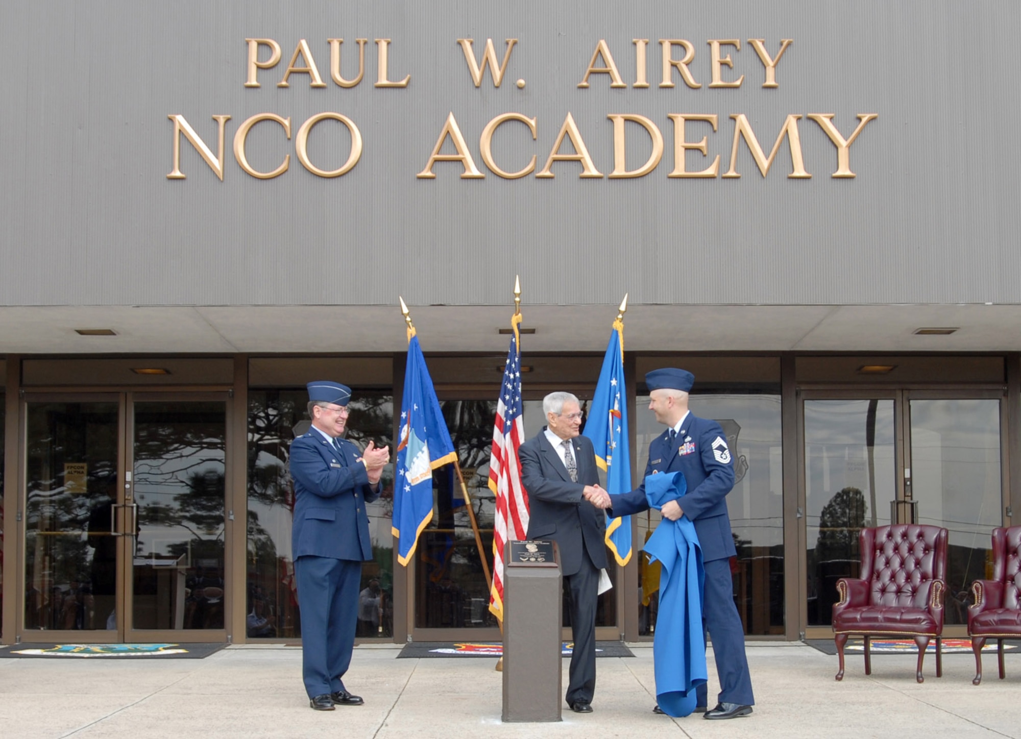 Chief Master Sgt. Thomas Schwenk congratulates former Chief Master Sgt. of the Air Force Paul Airey (center) after a dedication plaque was unveiled, while Col. Albert John Bowley Jr. looks on Dec. 13 at Tyndall Air Force Base, Fla. The Tyndall AFB NCO Academy was renamed the Paul W. Airey NCO Academy in honor the first chief master sergeant of the Air Force. Chief Schwenk is the commandant of the academy and Colonel Bowley is commander for the College for Enlisted Professional Military Education. (U.S. Air Force photo/Lisa Norman) 

