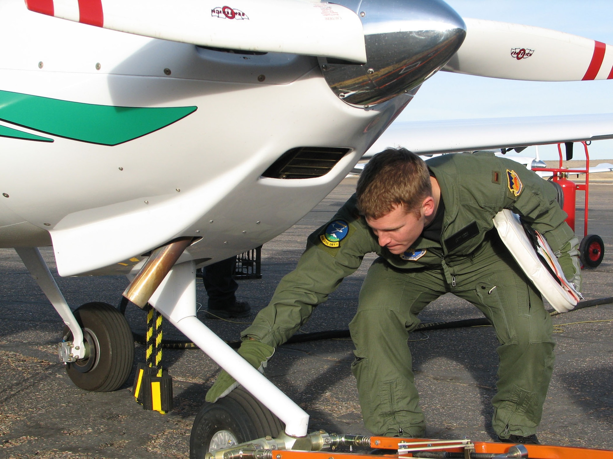 Second Lieutenant John Herd completes a post-flight inspection of the Diamond DA-20 trainer aircraft after finishing his final solo flight in the Initial Flight Screening program at Pueblo, Colo.  Lieutenant Herd is one of 16 members in the second IFS class to graduate the new program.  Eventually, plans call for up to 1,700 students per year to attend IFS at the new facility, which opened officially Friday (Dec. 15, 2006).  (U.S. Air Force photo by Tech Sgt Mike Hammond)