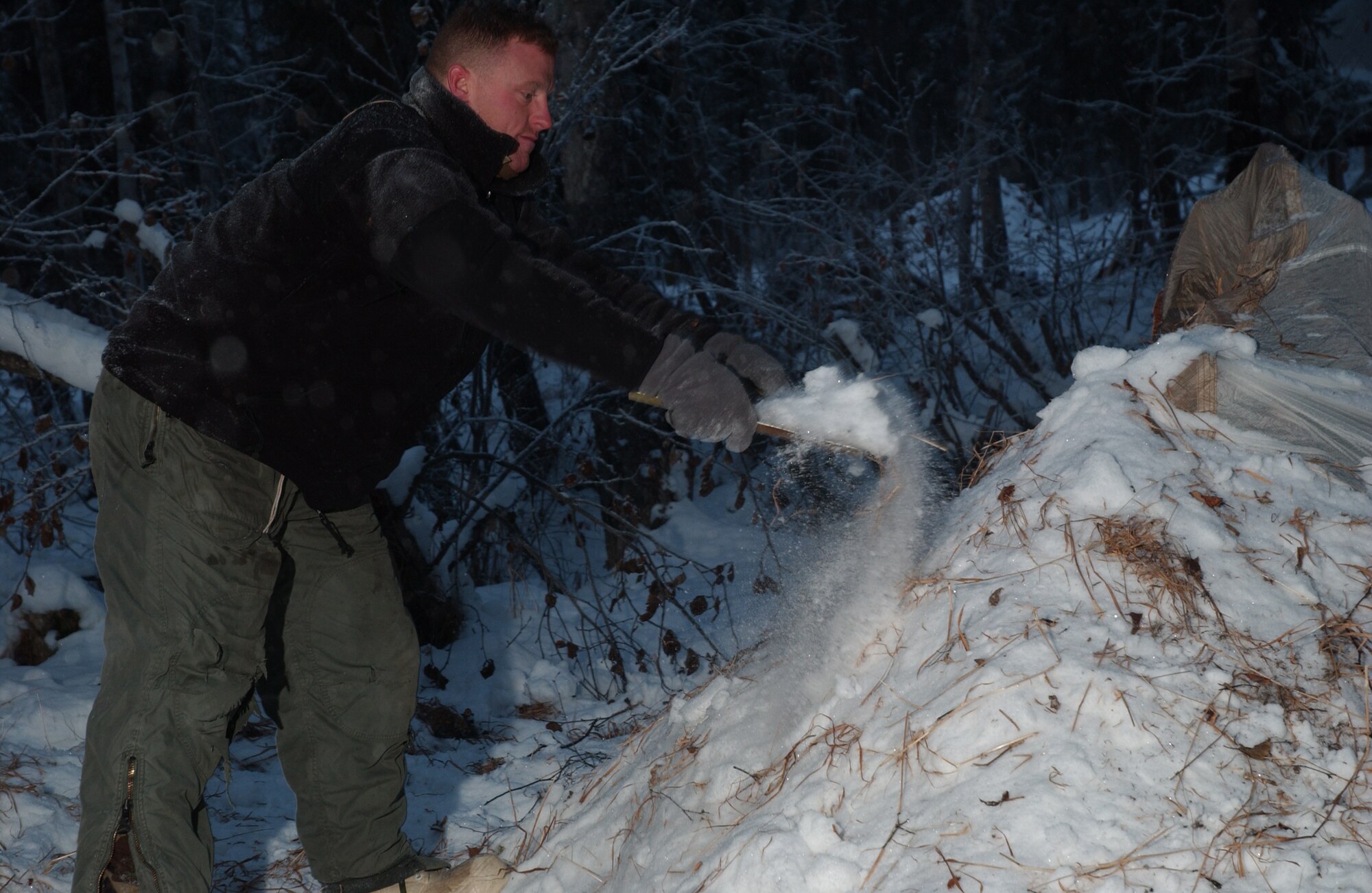 EIELSON AIR FORCE BASE, Alaska -- Senior Airman Ryan Perry of Fort Campbell, Kentucky, 19th Air Support Operations Squadron throws snow on top of his shelter on 14 December, 2006. He is participating in the Arctic Survival School only available at Eielson AFB. This five day course teaches the basic survival skills needed to know such as making fire, shelter, catching food and using flares to signal for help.
(US Air Force Photo by Airman Jonathan Snyder)