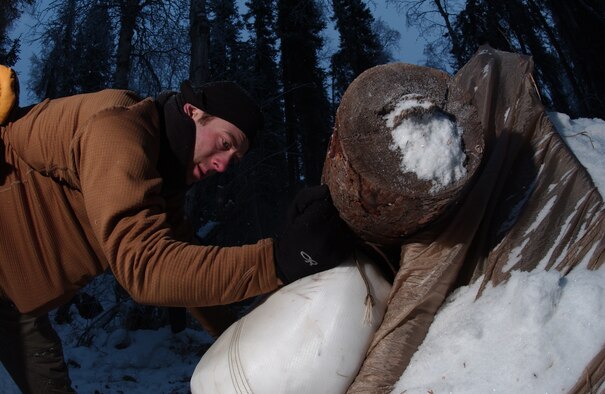 EIELSON AIR FORCE BASE, Alaska -- Staff Sgt. Mathew Scharder of Kulis Air National Guard Base, Alaska, 212th Pararescue Squadron places the canopy full of snow which will be used for the door for his shelter on 14 December, 2006. He is participating in the Arctic Survival School only available at Eielson. This five day course teaches the basic survival skills needed to know such as making fire, shelter, catching food and using flares to signal for help.  
(US Air Force Photo by Airman Jonathan Snyder)