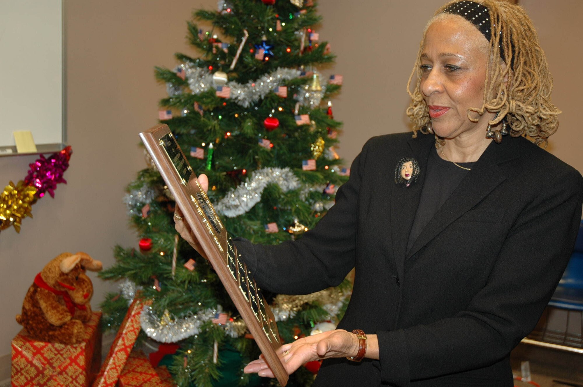 MCGUIRE AIR FORCE BASE, N.J. -- Ms. Cynthia Tyler-Mercer, mother of the late Senior Master Sgt. Tracy P. Tyler looks at the plaque that will hang on the wall of the Reserve unit on McGuire Air Force Base, N.J.,  in the memory of her daughter who died May 1, two weeks after suffering a stroke. Ms. Tyler-Mercer presented Tech. Sgt. Lenthel Drachler $500 Saturday, as the 514th Aeromedical Evaucation Squadron's first recipient of the SMSgt. Tracy P. Tyler Memorial Scholarship. (U.S. Air Force photo/Master Sgt. Donna T. Jeffries)