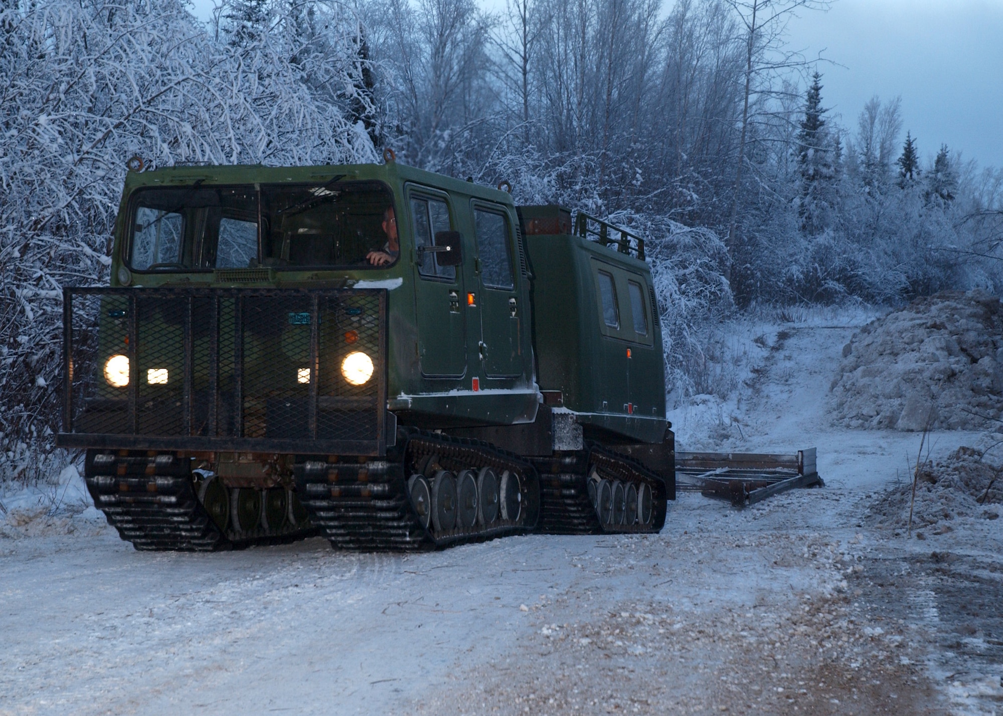 EIELSON AIR FORCE BASE, Alaska -- Timothy Ristow, 354th Civil Engineer Squadron, drives a Small Unit Support Vehicle with a grader to smooth out a road for access to the Blair Lake Bombing Range Facilities Dec. 13. The ice bridge takes about five weeks to complete in sub-zero weather. It is five-foot deep, a mile long and capable of supporting more than 110 tons -- which completely vanishes a few months later. The ice bridge helps 354th CES members access and perform annual maintenance on Eielson's training and bombing ranges. (U.S. Air Force photo by Airman Jonathan Snyder).
(Released) 