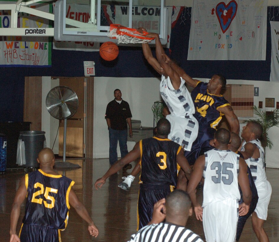 1st Lt. Tysen Pina an Airborne Weapons Officer with the 128th Airborne Command and Control Squadron slam dunks the ball against the All-Navy team during the All-Armed Services tournament. (Courtesy Photo)