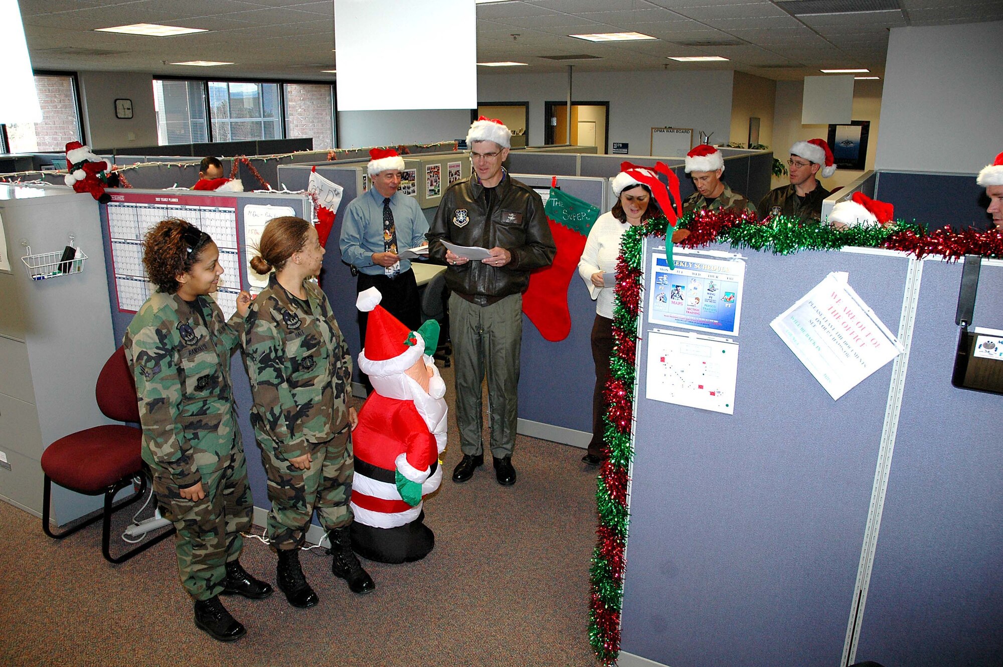 Col. Jay G. Santee, 21st Space Wing Commander, and his band of merry wing-staff elves spent a few hours Dec. 14 sharing holiday cheer.  The caroling crew visited numerous work centers and customer service areas around base, such as; maintenance, support, medical and operations work centers and the MPF and pharmacy.  Colonel Santee sends his holiday greetings to all Team 21 members, those home and deployed, and wishes each of them and their families a safe, happy and prosperous New Year and a safe return. (U.S. Air Force photo by Jeff Bohn)