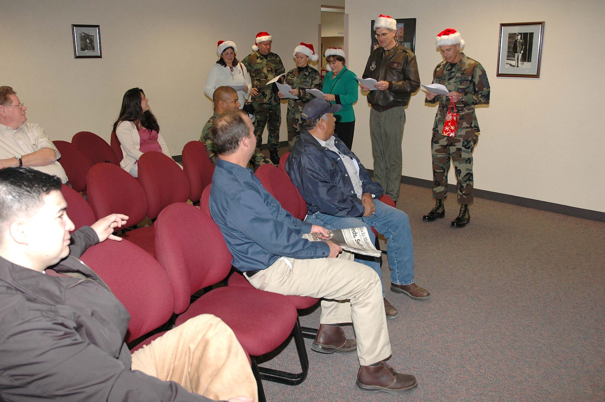 Col. Jay G. Santee, 21st Space Wing Commander, and his band of merry wing-staff elves spent a few hours Dec. 14 sharing holiday cheer.  The caroling crew visited numerous work centers and customer service areas around base, such as; maintenance, support, medical and operations work centers and the MPF and pharmacy.  Colonel Santee sends his holiday greetings to all Team 21 members, those home and deployed, and wishes each of them and their families a safe, happy and prosperous New Year and a safe return. (U.S. Air Force photo by Jeff Bohn)