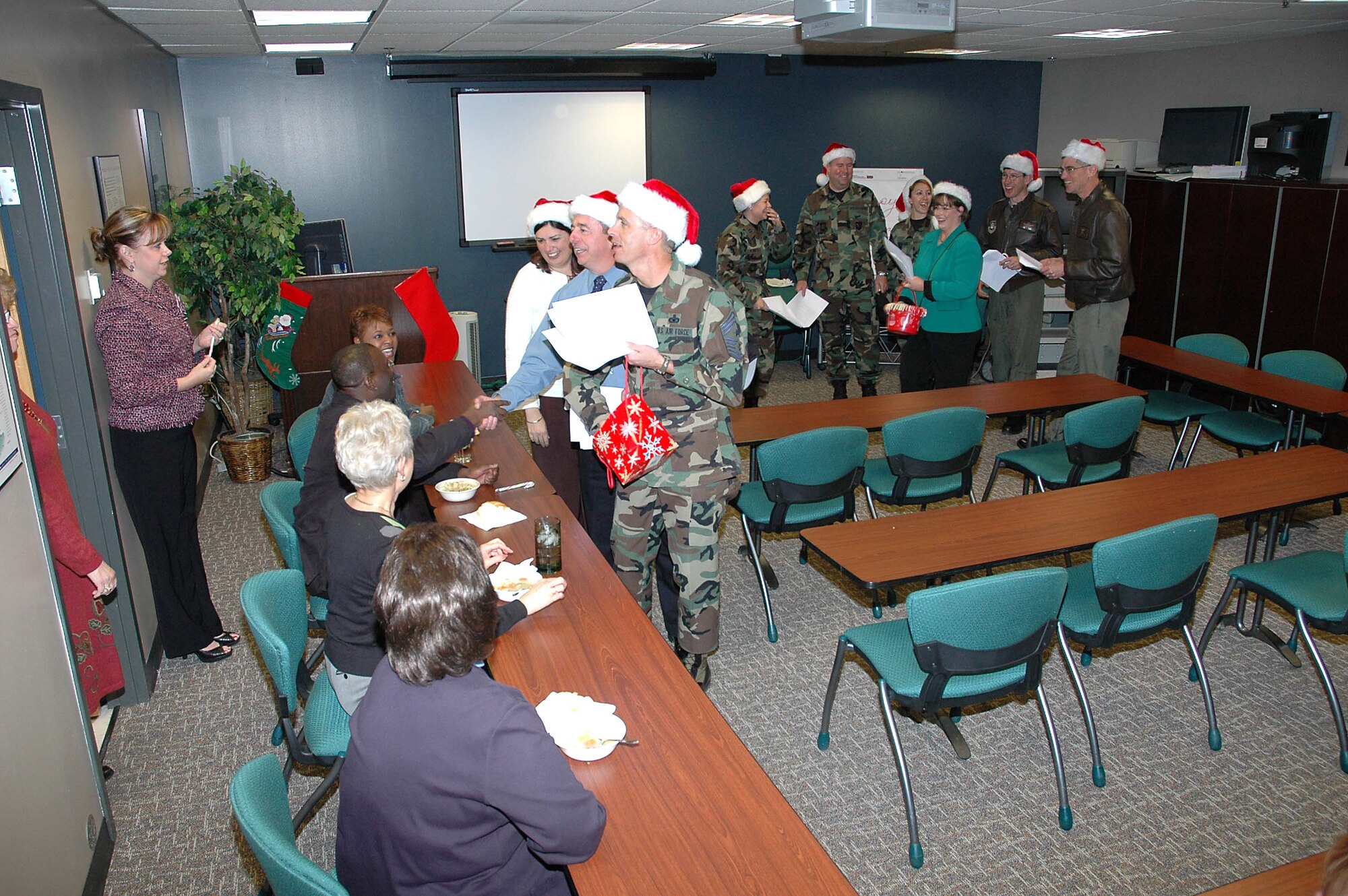 Col. Jay G. Santee, 21st Space Wing Commander, and his band of merry wing-staff elves spent a few hours Dec. 14 sharing holiday cheer.  The caroling crew visited numerous work centers and customer service areas around base, such as; maintenance, support, medical and operations work centers and the MPF and pharmacy.  Colonel Santee sends his holiday greetings to all Team 21 members, those home and deployed, and wishes each of them and their families a safe, happy and prosperous New Year and a safe return. (U.S. Air Force photo by Jeff Bohn)