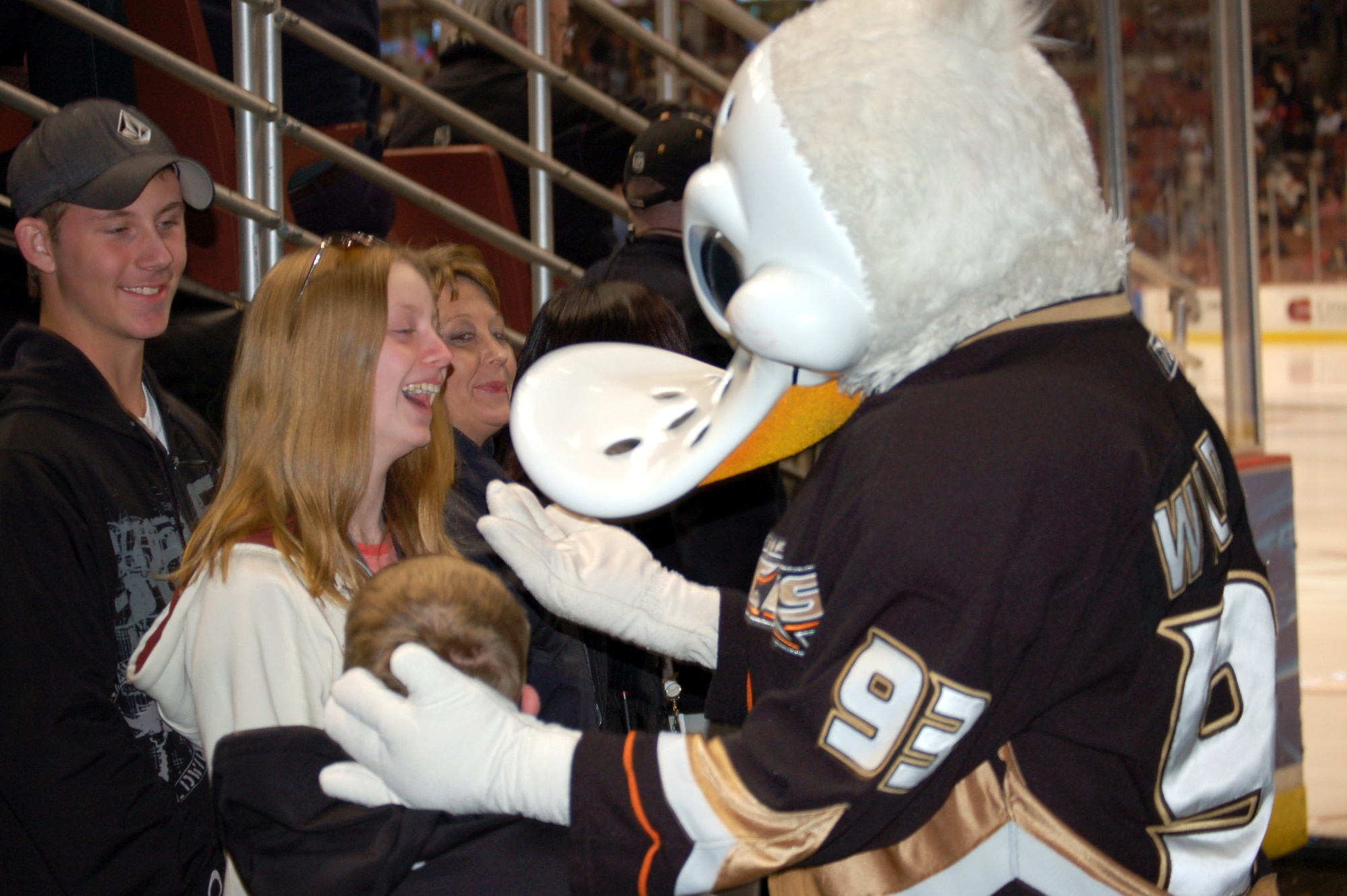 A family participating in the Snowball Express shares a laugh with the Anaheim Ducks mascot Wildwing Dec. 18. The game was the final activity of the four-day Snowball Express event. The event was open to all military families who lost someone in the war on terrorism. (U.S. Air Force photo/Senior Airman Brad Cameron) 
