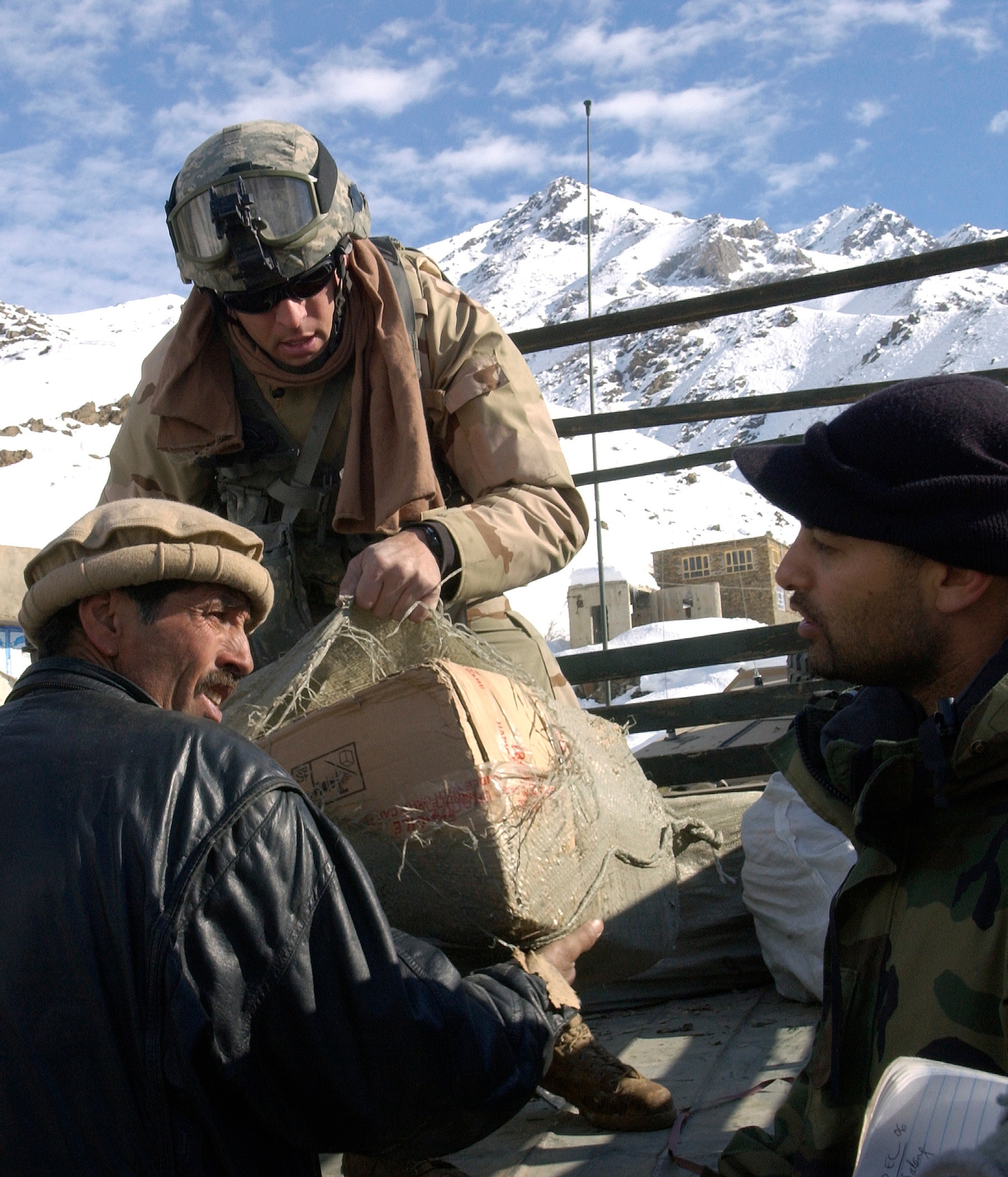 Tech. Sgt. Derril McDonald unloads a sack of humanitarian assistance relief supplies Dec. 12. McDonald and several other members of the Bagram Provincial Reconstruction Team delivered blankets, clothing and other supplies to help locals survive the winter. (U.S. Air Force photo/Senior Airman J.G. Buzanowski)                             