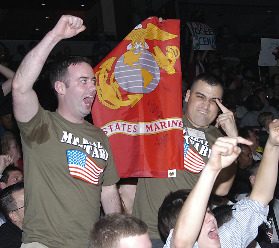 Marines Cpl. Patrick Murray (left) and Sgt. Jesse Diaz hoist the U.S. Marine Corps flag during the World Wrestling Entertainment Monday Night Raw event in Washington Dec. 18. Murray and Diaz were two of the 30 servicemembers from Walter Reed Army Medical Center invited to attend the event. Defense Department photo by Carmen L. Burgess