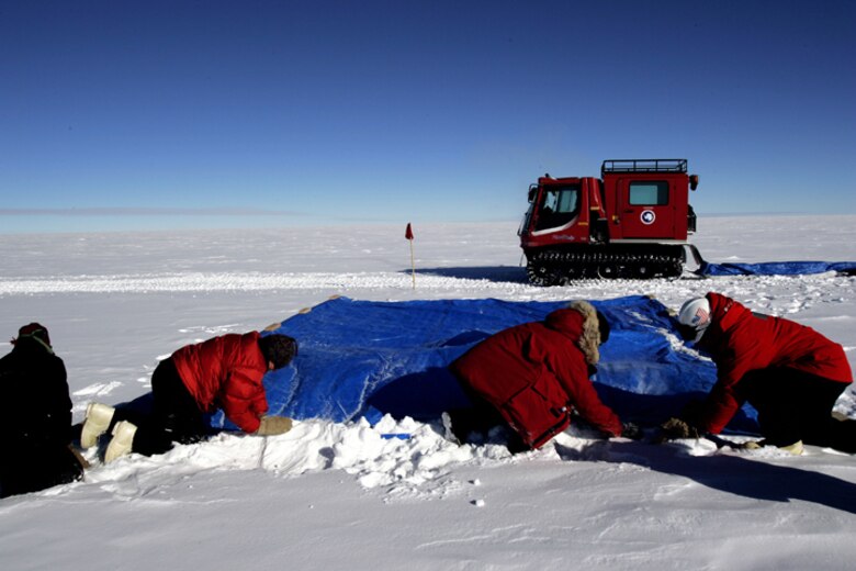 SOUTH POLE -- Members of the National Science Foundation work in the snow during the first C-17 Globemaster III airdrop to the South Pole, Dec. 20, 2006. Staffed by Airmen from McChord Air Force Base's 62nd and 446th Airlift Wings, the crew delivered 70 tons of supplies to the NSF. The mission was a "proof of concept" flight. 
(U.S. Antarctic Program/Forest Banks)