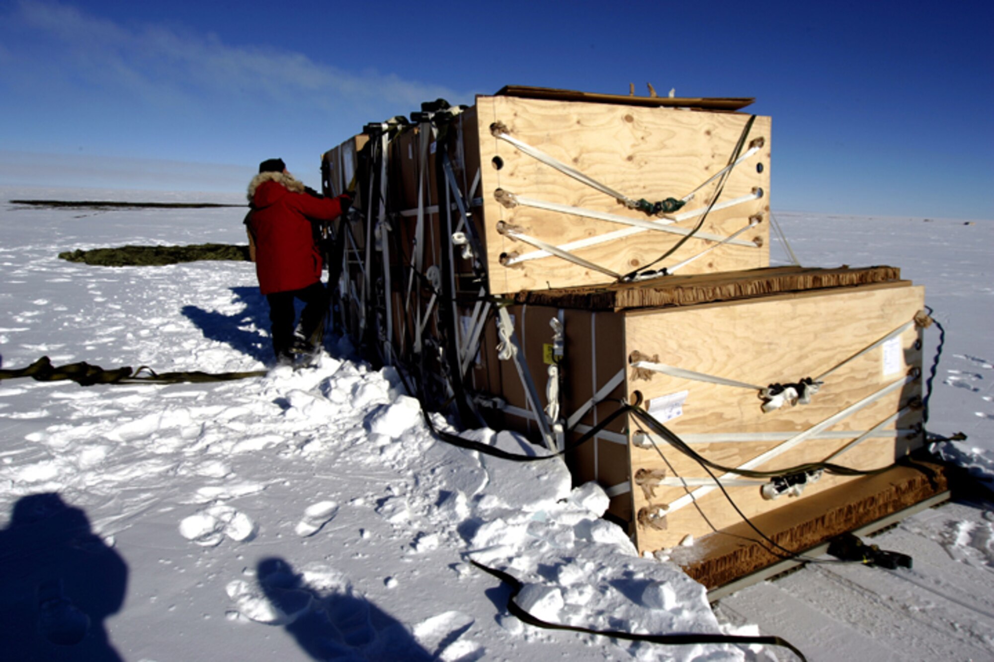 SOUTH POLE -- A member of the National Science Foundation stands near pallets of cargo delivered during the first C-17 Globemaster III airdrop to the South Pole, Dec. 20, 2006. Staffed by Airmen from McChord Air Force Base's 62nd and 446th Airlift Wings, the crew delivered 70 tons of supplies to the NSF. The mission was a "proof of concept" flight. 
(U.S. Antarctic Program/Forest Banks)