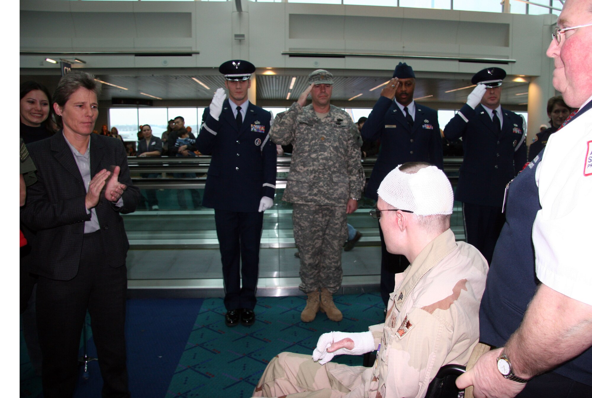 Members of the 939th Air Refueling Wing, Master Sgt. Klaus Bernkopf (left), Master Sgt. John Conway, and Master Sgt. John Brownfield and the Oregon Army National Guard Maj. Michael Warrington 141st Brigade Support Battalion commander saluted Army Sergeant John P. King for his service and welcomed him home as he arrived to the Portland International Airport Dec. 20, 2006. (U.S. Air Force Photo/Ruby Zarzyczny)