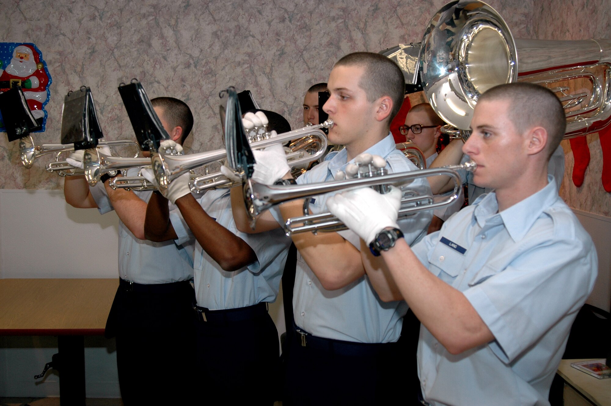 Trainees from the 737th Training Group Drum and Bugle Corps at Lackland Air Force Base, Texas, play holiday music for the residents of Grayson Square Health Care Center in San Antonio during a Christmas gift presentation by the 737th TRG and the Air Force Personnel Center on Dec. 20. Group and AFPC personnel adopt the residents, who range in age from 21 to 103, and bring wrapped gifts to help brighten the residents' holidays. (USAF photo by Staff. Sgt Tim Russer) 